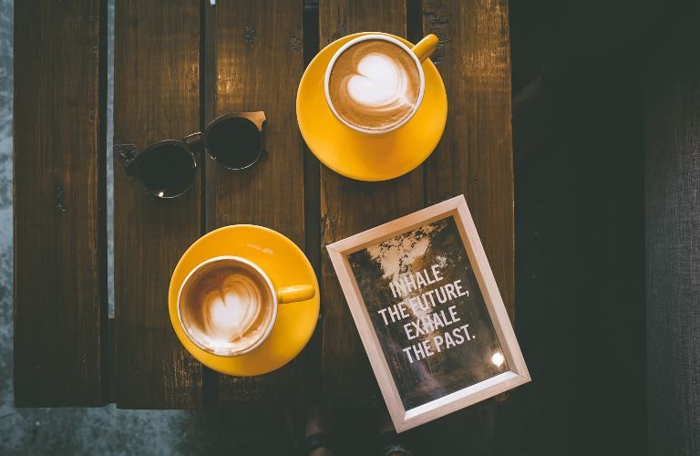 two coffee cups with a book